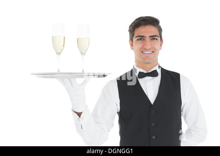 Smiling attractive tenant un plateau avec des verres de champagne sur elle Banque D'Images