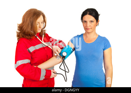 Contrôle de la pression artérielle au paramédic femme patient isolé sur fond blanc Banque D'Images