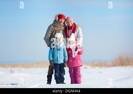 Heureux les parents et leurs enfants à l'extérieur de l'appareil photo à winterwear Banque D'Images