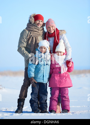 Heureux les parents et leurs enfants à l'extérieur de l'appareil photo à winterwear Banque D'Images