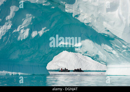 Bateaux gonflables Zodiac vu à travers l'arche d'un grand iceberg, Pléneau Bay, péninsule Antarctique, l'Antarctique Banque D'Images