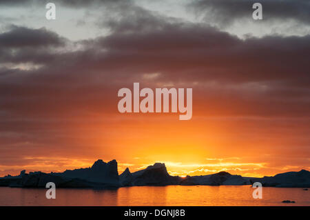 Coucher de soleil derrière les icebergs, l'île Booth, Pleneau Bay, péninsule Antarctique, l'Antarctique Banque D'Images