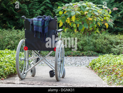 Fauteuil roulant abandonnés dans une zone verte, Berlin, Allemagne Banque D'Images