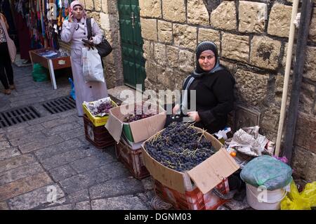 Jérusalem, Israël. 23 Oct, 2013. Une vieille femme arabe raisins vend près de la Porte de Damas comme derniers rayons de soleil sur la vieille ville de Jérusalem. Nir Alon/ZUMAPRESS.com/Alamy © Live News Banque D'Images