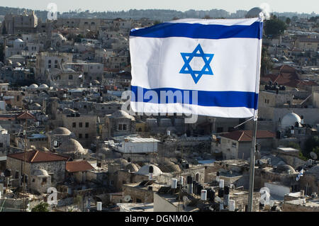 Jérusalem, Israël. 23 Oct, 2013. Le drapeau israélien des vagues dans l'avant-plan sur les toits des maisons de quartier musulman comme derniers rayons de soleil sur la vieille ville de Jérusalem. Nir Alon/ZUMAPRESS.com/Alamy © Live News Banque D'Images