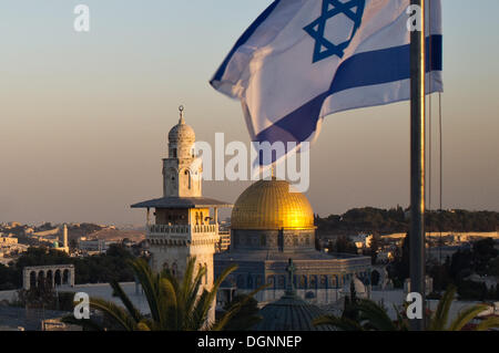 Jeruslaem, Israël. 23 Oct, 2013. Le drapeau israélien des vagues dans l'avant-plan en tant que derniers rayons de soleil sur la vieille ville de Jérusalem peindre le dôme doré de Haram al-Charif, l'un des plus importants sites religieux dans le judaïsme, le christianisme et l'Islam. Jérusalem, Israël. Credit : Alon Nir/Alamy Live News Banque D'Images