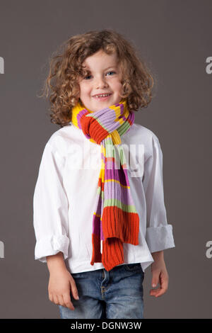 Fille aux cheveux roux, 5 ans, avec un voile et un jean Banque D'Images