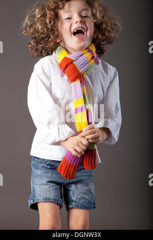Fille aux cheveux roux, 5 ans, avec un voile et un jean Banque D'Images