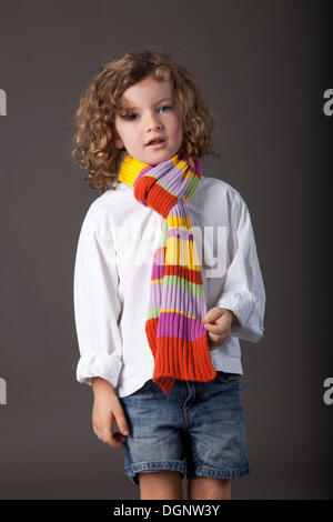 Fille aux cheveux roux, 5 ans, avec un voile et un jean Banque D'Images