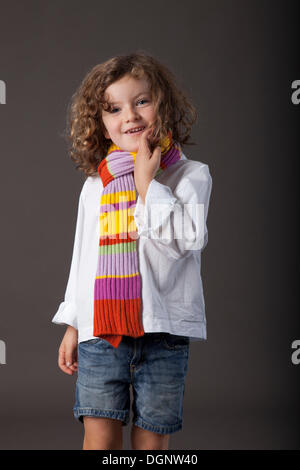 Fille aux cheveux roux, 5 ans, avec un voile et un jean Banque D'Images