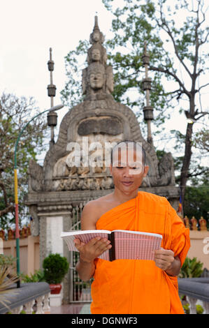 Le moine bouddhiste la lecture dans le Parc Royal, Siem Reap, Cambodge, en Asie du sud-est Banque D'Images