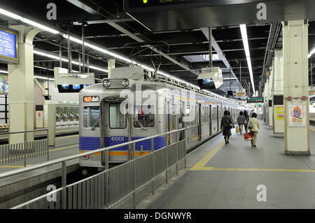 Train de la ligne de Nankai à la station sur une plate-forme avec une bande de guidage jaune pour les malvoyants sur le terrain et Banque D'Images