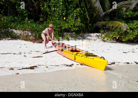 Femme avec un kayak à l'Anse Source d'argent, La Digue, Mahé, Seychelles, Afrique, Océan Indien Banque D'Images