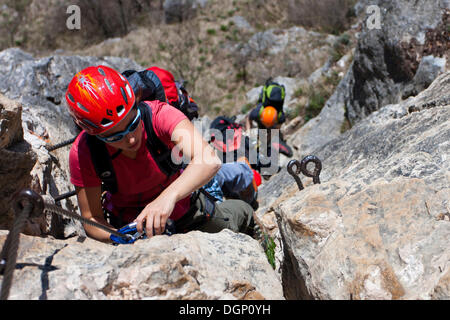 Les grimpeurs ordre croissant une via ferrata sur le Monte Albano au-dessus de Mori, Trentin, Italie, Europe Banque D'Images