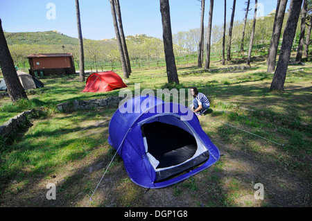 Jeune femme monte tente dans le camp des îles Cies paradisiaques (Islas Cies), réserve naturelle en Galice, Espagne Banque D'Images