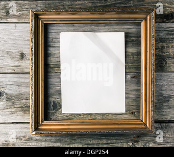 Vintage cadre doré avec du papier blanc froissé sur fond de bois vieux Banque D'Images