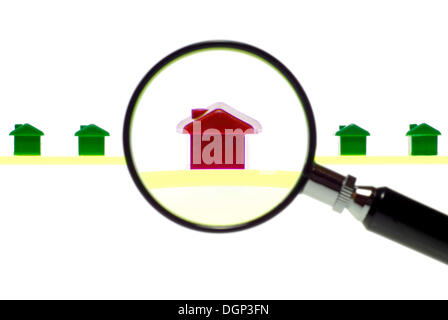 Modèles de maison sous la loupe, symbolique de l'habitation marché sous la loupe Banque D'Images