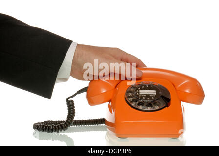 L'homme d'affaires pour atteindre un téléphone orange Banque D'Images