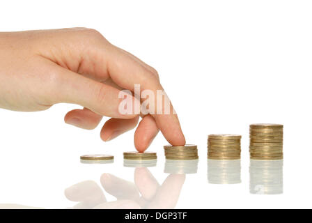 La main de femme qui monte escaliers faits de pièces de monnaie, l'image symbolique de l'accroissement des rendements Banque D'Images
