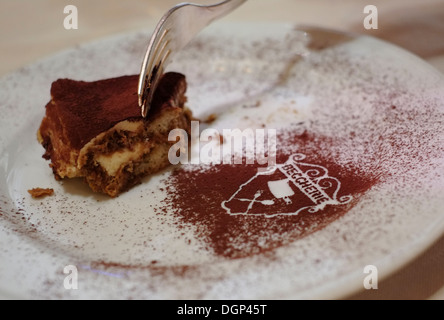 Tiramisu gâteau sur une assiette à Alle Beccherie Restaurant, Treviso, Italie. Banque D'Images