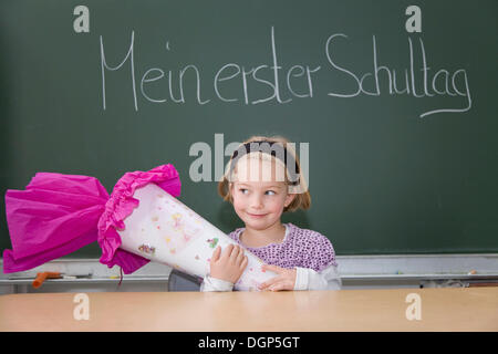 Fille avec un cône de bonbons sur sa première journée d'école Banque D'Images