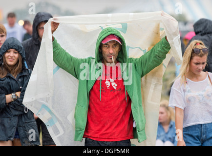 Le Reading Festival - un homme improvise un abri de la pluie Août 2013 Banque D'Images