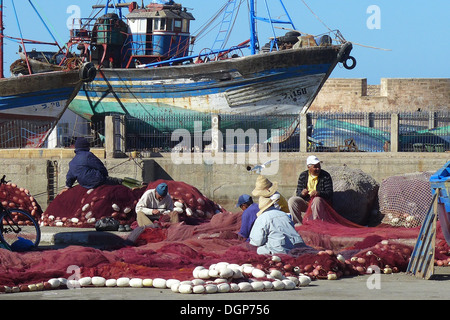 Maroc - Essaouira le port. Les pêcheurs réparer leurs filets. Banque D'Images