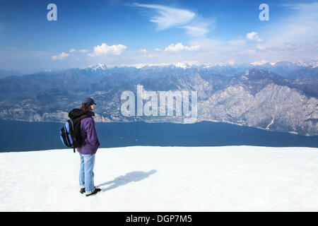 Randonneur admirant la vue depuis le Monte Baldo, sur le lac de Garde et les Alpes, le lac de Garde, Lombardie, Italie, Europe Banque D'Images