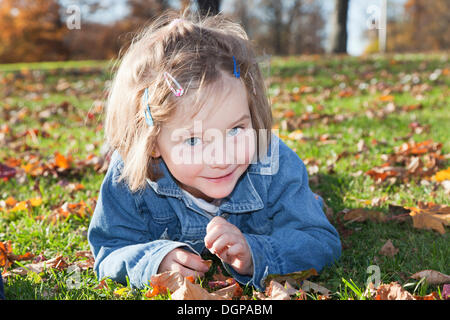 Fille, 4, dans un parc en automne Banque D'Images