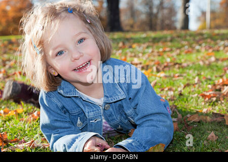 Fille, 4, dans un parc en automne Banque D'Images