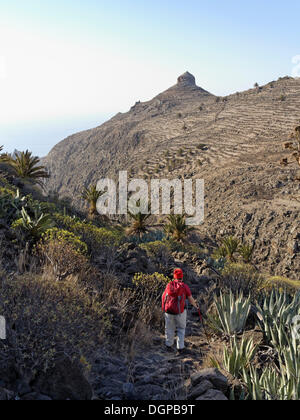 Roque del Sombrero, femme marche sur un sentier de randonnée dans le Barranco de la Guancha, La Gomera, Canary Islands, Spain, Europe Banque D'Images