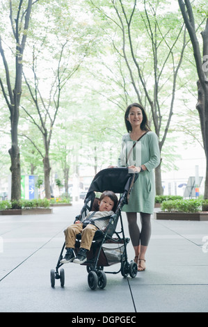 Mère avec fils assis dans la poussette, portrait Banque D'Images