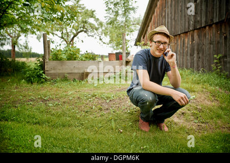 Jeune agriculteur parlant sur un téléphone mobile Banque D'Images