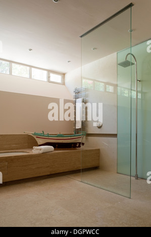 Cabine de douche en verre dans une salle de bains privative avec bateau de pêche modèle en bois Banque D'Images