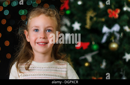 Peu smiling girl sur les décorations de Noël Banque D'Images