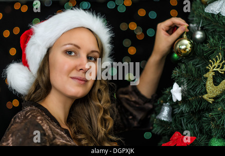 Jolie femme décore l'arbre de Noël Banque D'Images