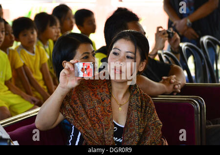 Le Nagaland, Inde. 24 Oct, 2013. Les femmes indiennes Boxing Champion et médaillé olympique, MC Mary Kom notice des clips de son mobile au cours d'une interaction avec les enfants de l'érable l'école après l'inauguration du Festival Sport Niathu à Jodhpur, Inde du nord-est de l'état de Nagaland le Jeudi, Octobre 24, 2013. Credit : ZUMA Press, Inc./Alamy Live News Banque D'Images