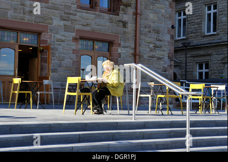 Vieille dame prenant le thé seul au café-terrasse table, Derry, Londonderry, en Irlande du Nord, Royaume-Uni Banque D'Images