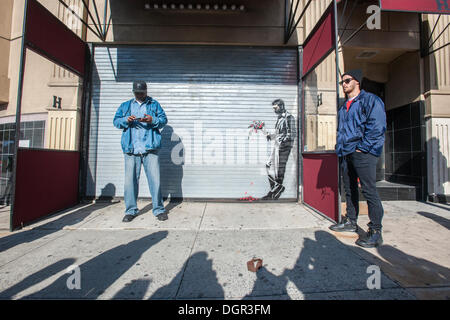 New York, NY, USA . 24 Oct, 2013. Les amateurs de street art affluent à Larry Flynt's Hustler Club dans le quartier Hell's Kitchen de New York le jeudi 24 octobre, 2013 pour voir 'attendre en vain' la vingt-quatrième tranche de graffiti de Banksy, l'art d'art au pochoir est sur le roll-up gate à l'entrée du club de gentlemen, qui a posté des gardes de sécurité à l'extérieur pour protéger leur nouveau chef d'œuvre. L'insaisissable artiste de rue, c'est la création d'œuvres autour de la ville chaque jour pendant le mois d'octobre intitulé "Mieux dehors que dans'. (© Richard B. Levine) Crédit : Richard Levine/Alamy Live N Banque D'Images