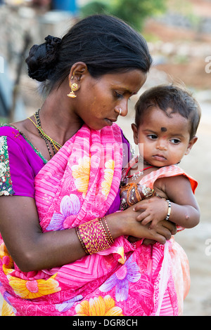 Les jeunes Indiens de caste inférieure teenage girl holding sa fille de bébé. L'Andhra Pradesh, Inde Banque D'Images