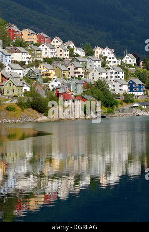 Maisons se reflétant dans l'eau du Sørfjord, Odda, province de Hordaland, Norvège, Europe Banque D'Images