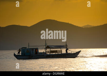 Banka, un bateau outrigger traditionnels philippins, ancré au large de la plage, dans la lumière du soir, Busuanga, Philippines, Asie Banque D'Images