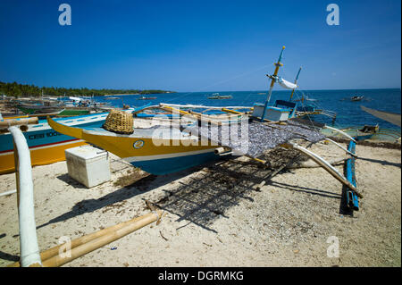 Banka, un bateau de pêche à balancier traditionnels philippins avec sardines séchées sur la plage, Malapascua, Philippines, Asie Banque D'Images