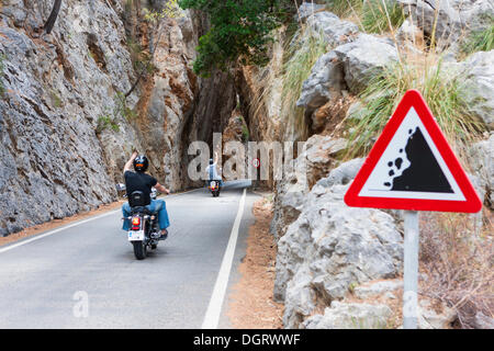 Les motocyclistes à travers un tunnel étroit le long de la route de montagne sinueuse de Sa Calobra, montagnes de Tramuntana, Majorque Banque D'Images