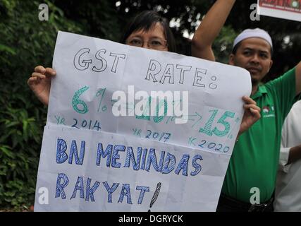 Kuala Lumpur, Malaisie, . 25 octobre, 2013. Une femme son visage avec l'anti-Taxe sur les produits et services (TPS) des pancartes au cours d'une manifestation qui se rassemble en face de la Maison du Parlement à Kuala Lumpur, Malaisie, le 25 octobre 2013. La Malaisie va enfin mettre en œuvre le retard de biens et services (TPS) à 6  % début avril 2015, pendant le premier ministre Datuk Seri Najib Razak a annoncé le Budget 2014.Photo : Firdaus Latif/NurPhoto : Crédit Firdaus/NurPhoto ZUMAPRESS.com/Alamy Latif/Live News Banque D'Images