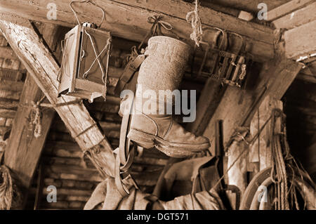 Ancienne étable d'une lanterne et d'avis boots suspendu dans un grenier, ferme de Franconie, Eckenhaid, Eckental, Middle Franconia, Bavaria, Germany Banque D'Images