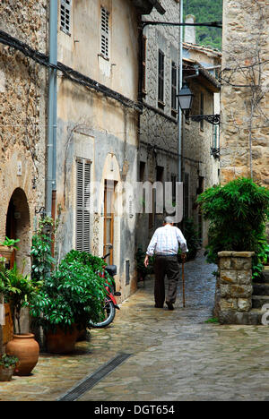 Vieil homme avec randonnées stick dans une ruelle, Valldemossa, Valldemosa, Mallorca, Majorque, Îles Baléares, Espagne, Europe Banque D'Images