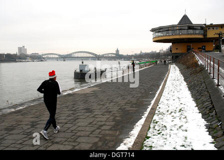 Jogger en hiver, promenade entre la rivière et la Konrad-Adenauer-Ufer shore, dans le dos la Bastei restaurant sur le Rhin Banque D'Images