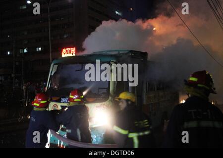 Dhaka, Bangladesh. 25 octobre, 2013. Les pompiers éteindre le feu couvant bangladais de l'épave un bus auraient été incendiés par des manifestants du Bangladesh burns sur une rue au cours d'une manifestation à Paris le 25 octobre 2013. Trois manifestants ont été tués à travers le Bangladesh et plus de 100 000 militants de l'opposition se sont rassemblés dans la capitale, Dhaka, d'exiger que le Premier Ministre Sheikh Hasina de fumer et de l'ordre dans le cadre de sondages d'un gouvernement intérimaire. Banque D'Images