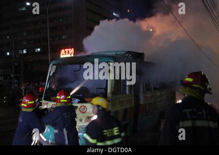 Dhaka, Bangladesh. 25 octobre, 2013. Les pompiers éteindre le feu couvant bangladais de l'épave un bus auraient été incendiés par des manifestants du Bangladesh burns sur une rue au cours d'une manifestation à Paris le 25 octobre 2013. Trois manifestants ont été tués à travers le Bangladesh et plus de 100 000 militants de l'opposition se sont rassemblés dans la capitale, Dhaka, d'exiger que le Premier Ministre Sheikh Hasina de fumer et de l'ordre dans le cadre de sondages d'un gouvernement intérimaire. Banque D'Images